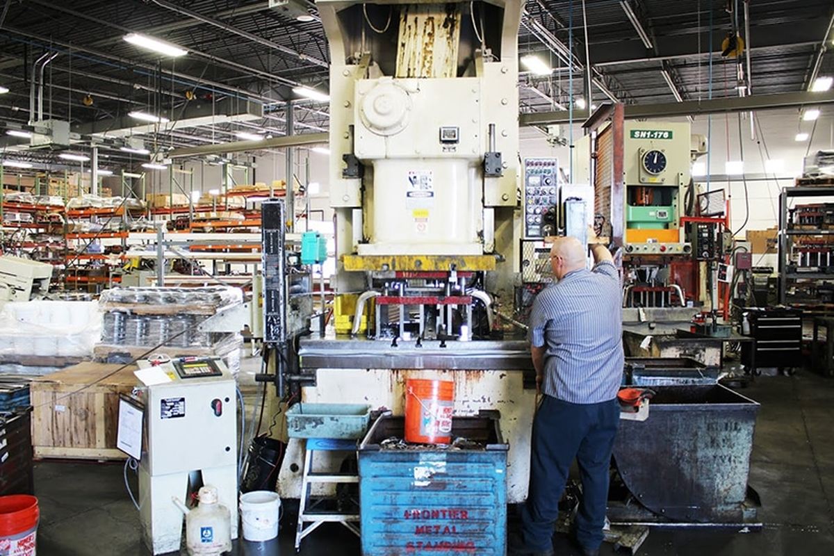 An operator running a press on the production floor