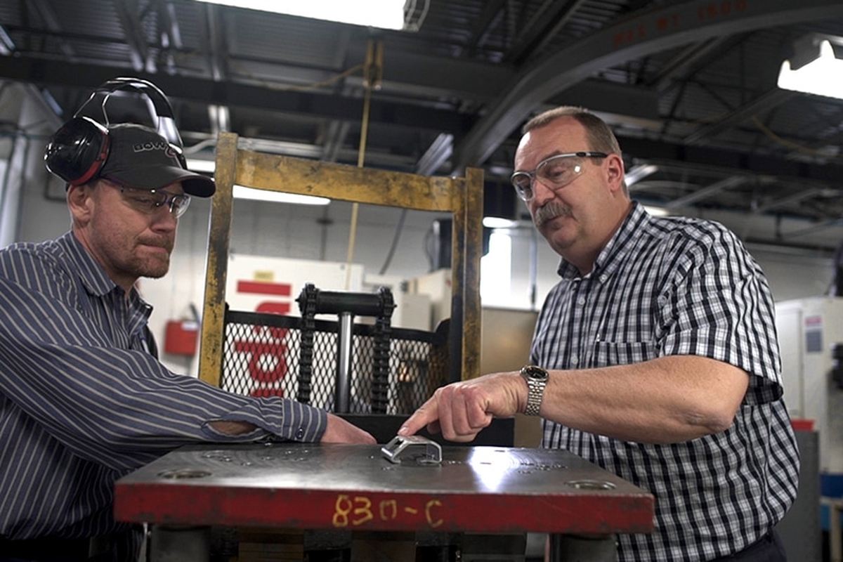 Two toolmakers working at a die