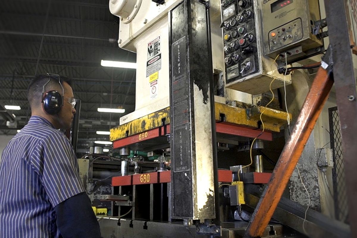 An operator at a stamping press