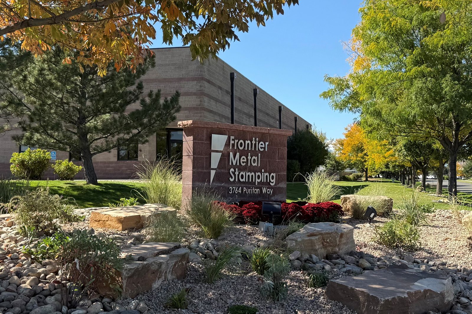 The Frontier Metal Stamping monument sign at 3764 Puritan Way, with the Frederick, Colorado plant behind it